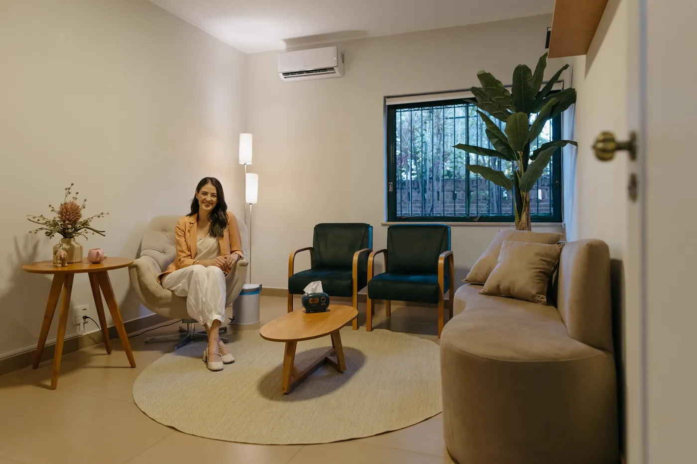 Profissional do Espaço Casulo em um consultório acolhedor, com plantas e luz natural